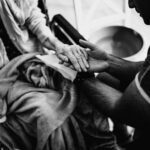https://www.pexels.com/photo/black-and-white-photo-of-a-man-holding-the-hand-of-an-elderly-woman-on-a-wheelchair-16364308/