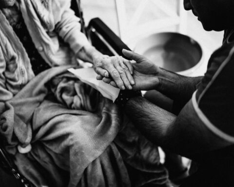 https://www.pexels.com/photo/black-and-white-photo-of-a-man-holding-the-hand-of-an-elderly-woman-on-a-wheelchair-16364308/